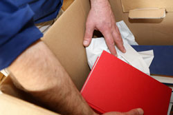 man putting books in a moving box